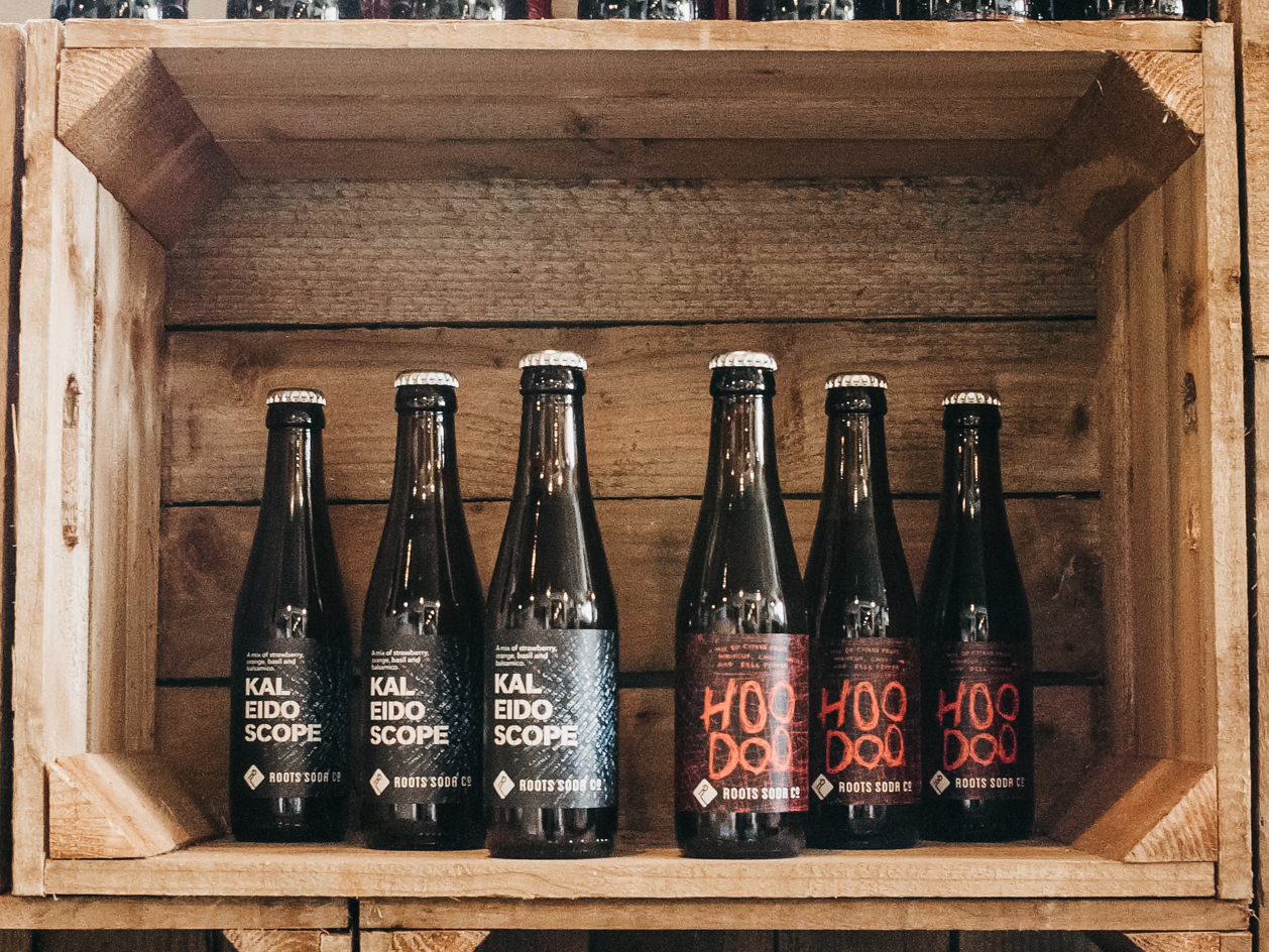 Roots Soda Co. Hoodoo and Kaleidoscope in a wooden crate.